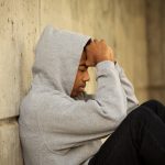 Man Sitting on Street Distressed