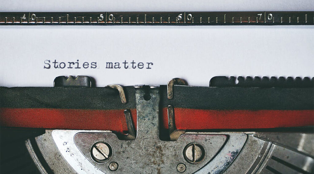 A close-up of a vintage typewriter with a piece of paper in it that reads 'Stories matter'.