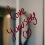 Love yourself written in lipstick on a mirror, for a Self-Care blog for Eli's Place by Rickey Miller