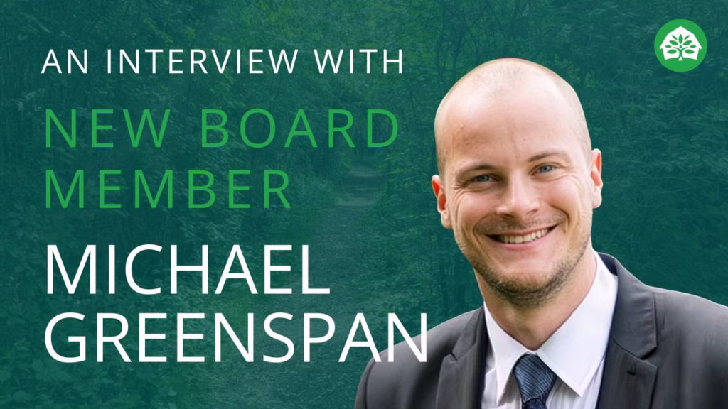 An interview with new board member Michael Greenspan text overlay on a background of a lush green forest path.