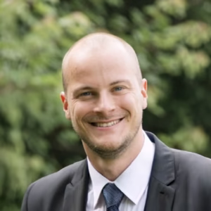An interview with new board member Michael Greenspan text overlay on a background of a lush green forest path.